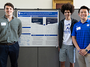 Student researchers beside poster
